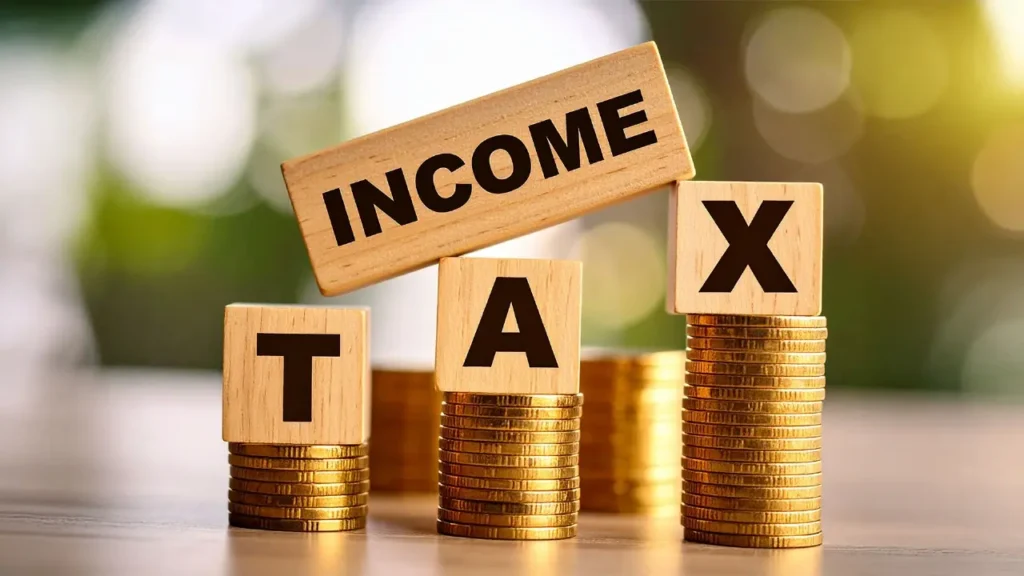 Income tax blocks on stacked coins, symbolizing tax preparation services for high net worth individuals and complex financial situations.