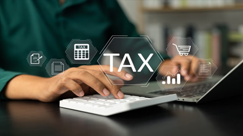 Person typing on a laptop with a calculator, surrounded by tax-related icons, illustrating tax preparation services for high net worth individuals.